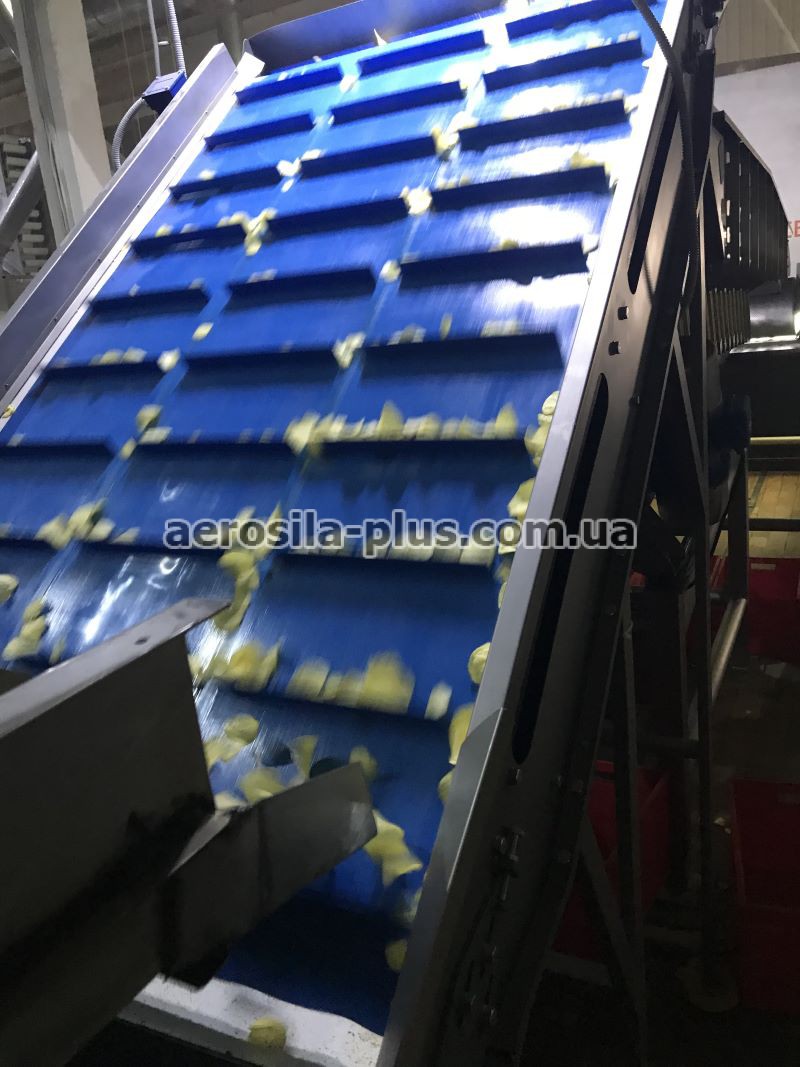 Подавальний конвеєр під бункером у виробничому цеху
